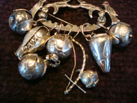 Vintage silver jewelry, a beautiful Andean (Peru or Ecuador) charm broach, c. 1930's. The broach has seven unique silver charms. Closeup photo of the charm bracelet.
