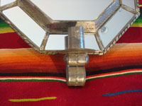 Mexican vintage tin-art (tinwork art), an octagonal tinwork mirror with a single candleholder at the base, c. 1930-40. Closeup of the candleholder at the base.