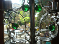 BU-3: Mexican vintage tinwork art, and Mexican vintage folk art, a lovely tinwork-art candlelabra with five green glass spheres as decorations, Oaxaca, c. 1940's. Closeup photo showing the glass spheres decorating the tinwork art candlelabra.