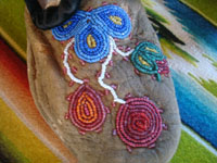 Native American Indian vintage beadwork, and vintage folk art, a beautiful pair of Cree child's mocassins with very fine and colorful beadwork, c. 1920's or earlier. Closeup of the front of one mocassin showing the very fine beadwork designs.
