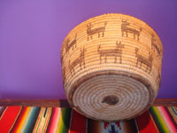 Native American Indian baskets, a beautiful Pima woven pictorial basket showing a man and 19 animals, Arizona, c. 1930's.  A side view of the basket.