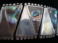 Closeup photo of Mexican vintage silver jewelry, Taxco sterling silver bracelet inlaid with abalone shell.