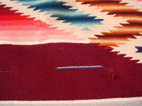 Mexican vintage textiles, a Saltillo sarape, c. 1940. Beautiful burgundy background. Made of very finely woven wool with silk in the center medallion and decorative side-bars.  Closeup.