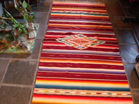 Mexican vintage textiles, a Saltillo sarape, c. 1940. Beautiful burgundy background. Made of very finely woven wool with silk in the center medallion and decorative side-bars.  Main photo.