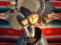 Mexican vintage tin-art (tinwork-art) and Mexican vintage devotional and folk art, a tin-art Virgin with Child, c. 1960. The stamping on the tinwork is wonderful, and the faces of the Virgin and Child are ceramic and are beautifully painted. Closeup photo of the Virgin and Child.