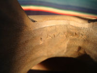 Native American Indian wood-carving and folk art, a Northwest Coast carved wooden miniature mask in the form of a bear with abalone inlaid eyes, signed LAVALLE, c. 1960's. Closeup photo showing the maker's signature, LAVALLE.