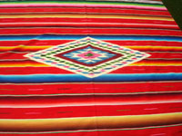 Mexican vintage textiles and Saltillo serapes (sarapes), a wonderful Saltillo serape with a red background and a beautiful center medallion, Saltillo, Coahuilla, c. 1940. Closeup photo of the lovely center medallion of the serape.