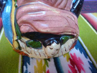 Mexican vintage folk art, a pottery bottle representing Our Lady of Guadalupe, Tonala or San Pedro Tlaquepaque, c. 1930's. Closeup photo of the angel at the Virgen's feet.