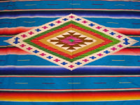 Mexican vintage textiles and sarapes, a beautiful Saltillo sarape with a turquoise background and wonderful center medallion, c. 1940. A closeup photo of the center diamond.