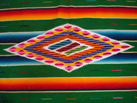 Mexican vintage textiles and sarapes, a beautiful Saltillo sarape with a green background, c. 1940's. Very fine wool with silk in the center medallion and decorative side bars. Closeup photo of the center diamond of the sarape.