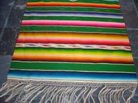 Mexican vintage textiles and sarapes, a beautiful Saltillo sarape with a green background, c. 1940's. Very fine wool with silk in the center medallion and decorative side bars. Photo showing one end of the sarape with fringe.