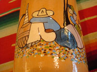 Mexican vintage pottery and ceramics, and Mexican vintage folk art, a pottery bottle from Tlaquepaque, Jalisco, c. 1930. The bottle has a lovely cream-colored background, with a wonderful scene of a snoozing Mexican campesino with his burro amidst wonderful trees and cacti. The artwork on this piece is exceptionally fine. A closeup photo of the snoozing campesino.