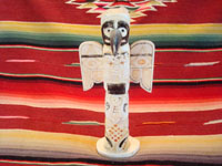 Native American Indian antique folk art, a carved, bone totem pole from Alaska, c. 1920-30's. The figure of the Raven with outstretched wings (the mythical hero of the Tlingit) hovers at the top of the pole, sheltering the three children of the sun. Main photo of the totem pole.