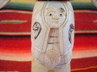 Native American Indian antique folk art, a carved, bone totem pole from Alaska, c. 1920-30's. The figure of the Raven with outstretched wings (the mythical hero of the Tlingit) hovers at the top of the pole, sheltering the three children of the sun. Photo of the center of the pole showing a face.