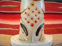 Native American Indian antique folk art, a carved, bone totem pole from Alaska, c. 1920-30's. The figure of the Raven with outstretched wings (the mythical hero of the Tlingit) hovers at the top of the pole, sheltering the three children of the sun. Closeup photo of the bottom of the pole, showing what looks like a mythical whale figure.