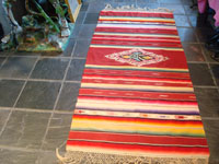 Mexican vintage sarapes and textiles, an incredible Saltillo sarape with a beautiful center medallion, c. 1930's. The predominant color of this multi-colored piece is a beautiful red. Main photo of the Saltillo sarape.