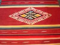 Mexican vintage sarapes and textiles, an incredible Saltillo sarape with a beautiful center medallion, c. 1930's. The predominant color of this multi-colored piece is a beautiful red. Photo showing the center medallion of the Saltillo sarape.