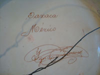 Mexican vintage pottery and ceramics, a large charger from Oaxaca with a wonderful floral pattern, c. 1940's. A photo showing the artist's signature on the back side of the charger.
