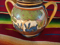 Mexican vintage pottery and ceramics, a lidded jar with handles from Tlaquepaque, Jalisco, c. 1930's. The lidded jar has the petatillo hatch-work pattern in the background, and features two wonderful blue bunnies amidst foliage on both the front and the back. A photo of the bunnies on back side.