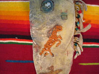 Native American Indian beadwork and folk art, a Plains knife-sheath with ghost-dance designs and symbolism, c. 1890-1910. The sheath is sinew sown with brain-tanned leather, and with fringe and bottom-tassles with beads. Closeup of beadwork horse on the front.
