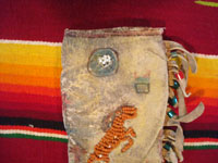 Native American Indian beadwork and folk art, a Plains knife-sheath with ghost-dance designs and symbolism, c. 1890-1910. The sheath is sinew sown with brain-tanned leather, and with fringe and bottom-tassles with beads. Closeup photo of the symbols near the top of the sheath.