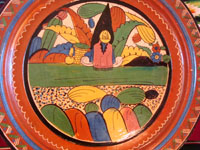 Mexican vintage pottery and ceramics, a wonderful charger from Tlaquepaque, c. 1930-40. Beautifully decorated with a Diego Rivera-like scene of a woman kneeling as she contemplates lovely flowers. Closeup of the front of the charger with scene of a kneeling woman.