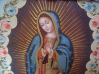 Mexican fine art, an oil painting of Our Lady of Guadalupe in a very fine wood carved frame from 1930, the painting is from c. 1950. Closeup photo of the Virgen.