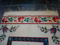 Mexican vintage sarapes and textiles, a lovely weaving from Oaxaca, c. 1910-20. The textile features lovely roses; it is an incredible piece of art. Closeup photo of one edge of the textile showing the lovely border.