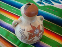 Mexican vintage folk art, and Mexican vintage pottery and ceramics, a pottery figure of a seated person, with wonderful hand-painted decorations in the style of the state of Guerrero, Tulimon, Guerrero, c. 1970. Photo showing the back side of the seated Guerrero figure.