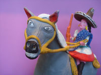 Mexican vintage folk art, a wonderful pottery statue of a woman brandishing her rifle and mounted on a spirited horse, Santa Cruz de las Huertas, Jalisco, c. 1950's. Closeup view of the horse's face.