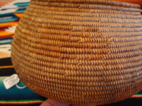 Photo of the side of the Mission Indian basket showing the contiuation of the rattlesnake design ending with the head and fangs.