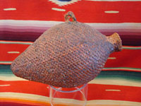 I-2: Native American Indian basket, an Apache tus, or water jar, c. 1910. Tightly woven and covered with tar or pine pitch to make the jar waterproof. Size: 8" tall x 5" wide at widest part. Price: $350.