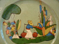 Closeup photo showing the hand-painted village scene on the Talquepaque pottery plate from Jalisco, Mexico.