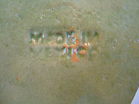A closup photo showing the signature stamped onto the back of the vintage Mexican pottery plate from Tlaquepaque.
