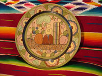 Mexican vintage pottery and ceramics, a petatillo plate from Tlaquepaque, c. 1920-30. This piece is wonderfully hand-painted with a scene of a man sitting in front of a cactus and other colorful plants. Main photo of plate.
