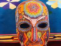 CI-13: Mexican vintage woodcarvings and masks, a beautiful beaded Huichol mask with very intricate and crisp design elements, the Sierras of Nyarite, c. 1950's. Closeup photo of the top part of the mask, showing the peyote bud on the front above the eye-openings.