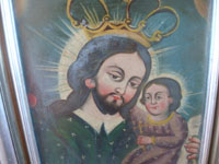 Mexican and New Mexican vintage devotional art, a New Mexican tin retablo painted with the images of St. Joseph and the Child Jesus, New Mexico, c. 1930's. Closeup photo of the faces of St. Joseph and the Child Jesus.