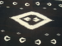 Mexican vintage textiles and sarapes, a lovely woven wool textile with a black background and all naturally colored wool, Tlaxcala, c. 1950. A closeup photo of the center medallion.
