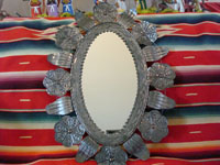 Mexican vintage tin-work, a tin mirror with copper, c. 1950. Size: 25 1/2 inches tall by 15 inches wide. Beautiful floral decorations and wonderful stamping.