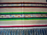 Mexican vintage textile, a Saltillo sarape, c. 1920. Woven of very fine wool with silk in the center diamond and side-bar decorations.  A closeup photo of one end of the Saltillo sarape.