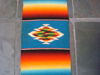 Mexican vintage textile, a Saltillo Sarape, c. 1940. This is a very fine narrow runner, with a rainbow-style of coloration. Very fine wool with a beautiful center diamond. Photo of the center of the Saltillo Sarape runner.