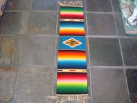 Mexican vintage textile, a Saltillo Sarape, c. 1940. This is a very fine narrow runner, with a rainbow-style of coloration. Very fine wool with a beautiful center diamond.