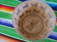 Native American Indian antique woven baskets and basket-weaving, a stunning Pima basket decorated with a figure of a man throwing a stick to his nineteen doggies, Pima, Arizona, c. 1915-20.  Photo shot from above the Pima basket, looking down.