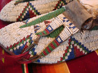Native American Indian antique beadwork, a pair of Sioux (Lakota) beaded mocassins, c. 1890. The beadwork is exceptionally fine. The mocassins have a bi-furcated tongue. Closeup photo.