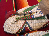 Native American Indian antique beadwork, a pair of Sioux (Lakota) beaded mocassins, c. 1890. The beadwork is exceptionally fine. The mocassins have a bi-furcated tongue. A second closeup photo showing the bi-furcated tongue.