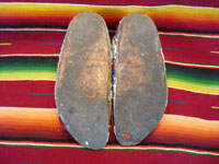 Native American Indian antique beadwork, a pair of Sioux (Lakota) beaded mocassins, c. 1890. The beadwork is exceptionally fine. The mocassins have a bi-furcated tongue. A photo showing the bottoms of the mocassins.