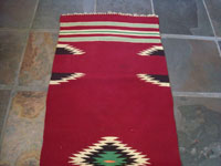New Mexican vintage textile, a weaving from Chimayo, New Mexico, c. 1930's. The textile has a very deep burgundy background, and the colors are bright and very beautiful.  A photo of the bottom half of the textile.