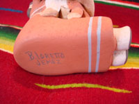 Native American Indian pottery and folk art, a story-teller from Jemez Pueblo with five children, signed B. Laretto, c. 1980. The grandmother's mouth is open, and the five children are obviously enthralled by her stories. A photo of the bottom of the figure showing the artist's signature.