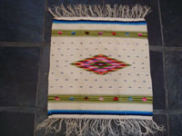 Mexican vintage textiles and sarapes, a Saltillo sarape with a white background and a very fine silk center-medallion and decorative side-bars, c. 1920's. Very beautifully woven with the fine fringe intact at both ends. Main photo of sarape.