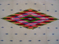 Mexican vintage textiles and sarapes, a Saltillo sarape with a white background and a very fine silk center-medallion and decorative side-bars, c. 1920's. Very beautifully woven with the fine fringe intact at both ends. Closeup photo of the center diamond.